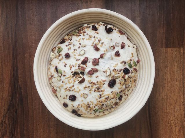 Bread dough with seeds and dried fruit in a bowl
